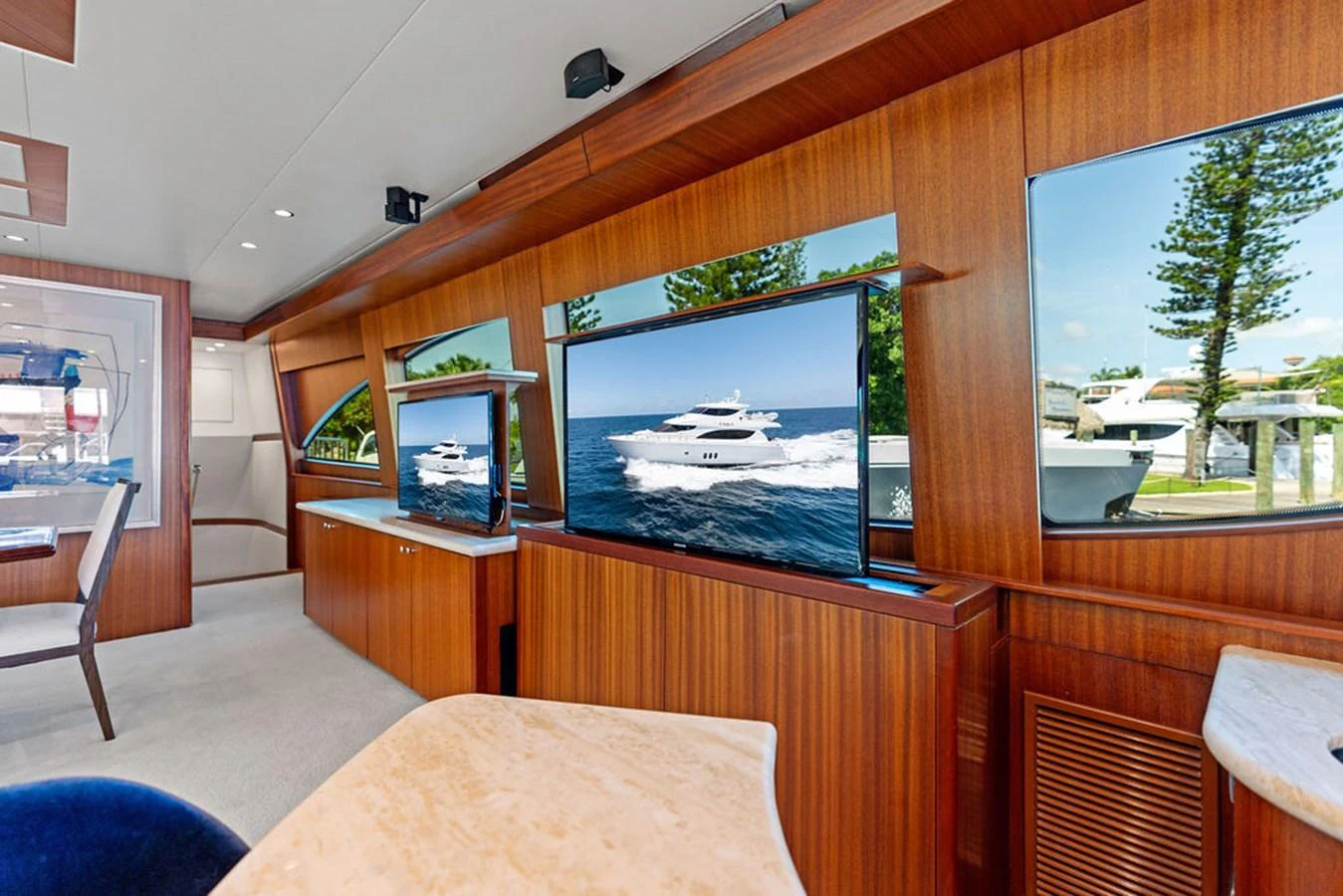 The salon features elegant wood paneling, large windows, and a flat-screen TV for a luxurious onboard experience. aboard GRIFFIN Yacht for Sale