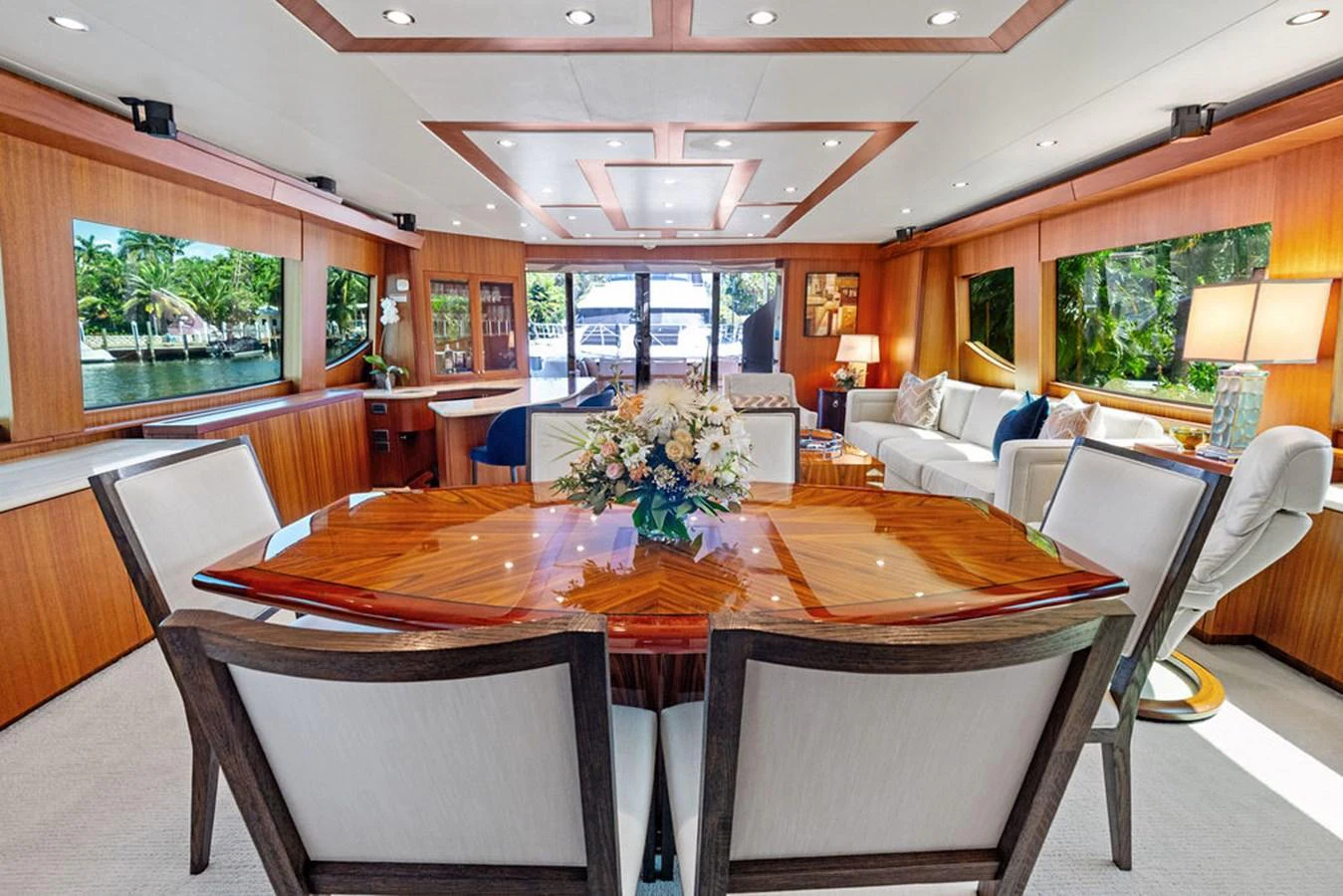 The yacht's salon features elegant wood finishes, a large dining table, and ample natural light. aboard GRIFFIN Yacht for Sale