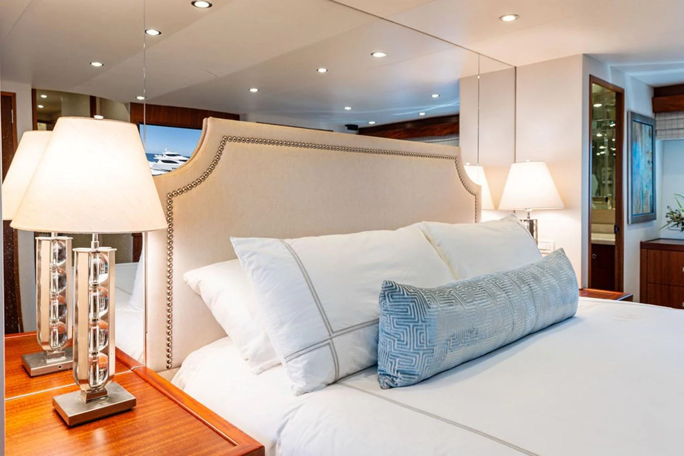The stateroom features a luxurious bed with elegant bedding and ambient lighting. aboard GRIFFIN Yacht for Sale