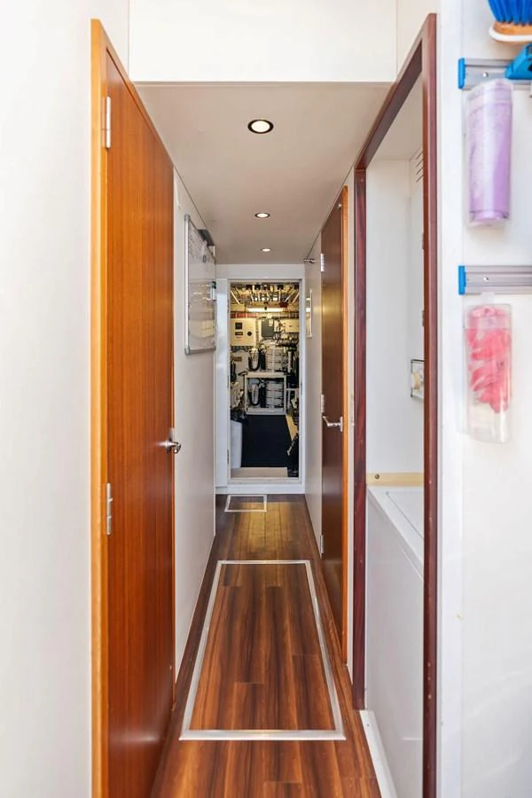 A sleek hallway with wooden doors and flooring leads to the yacht's engine room. aboard GRIFFIN Yacht for Sale