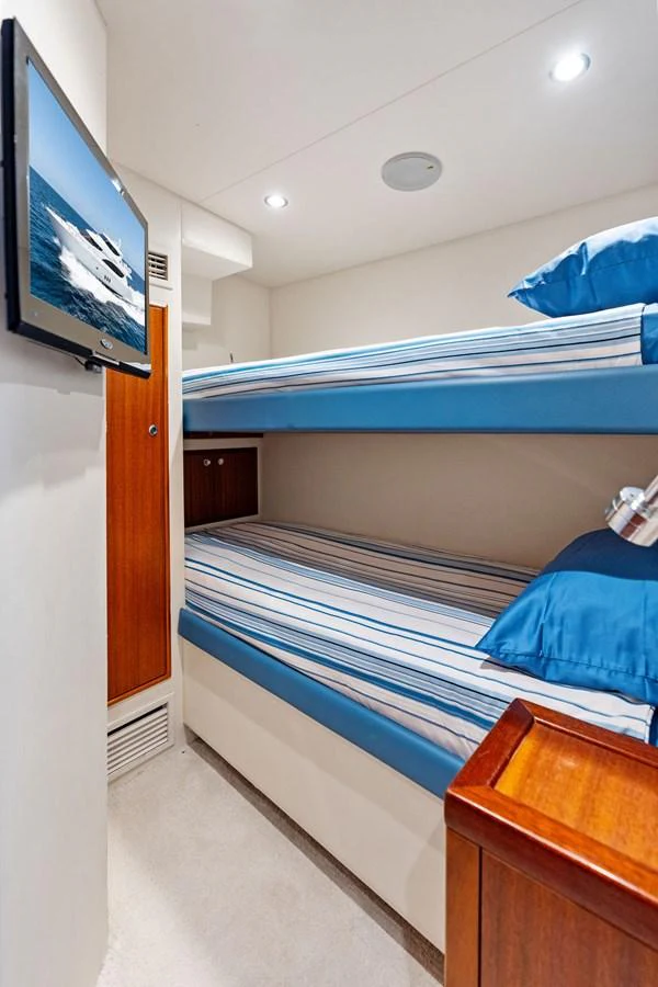 The cozy bunk cabin features comfortable bedding and a mounted TV for entertainment. aboard GRIFFIN Yacht for Sale