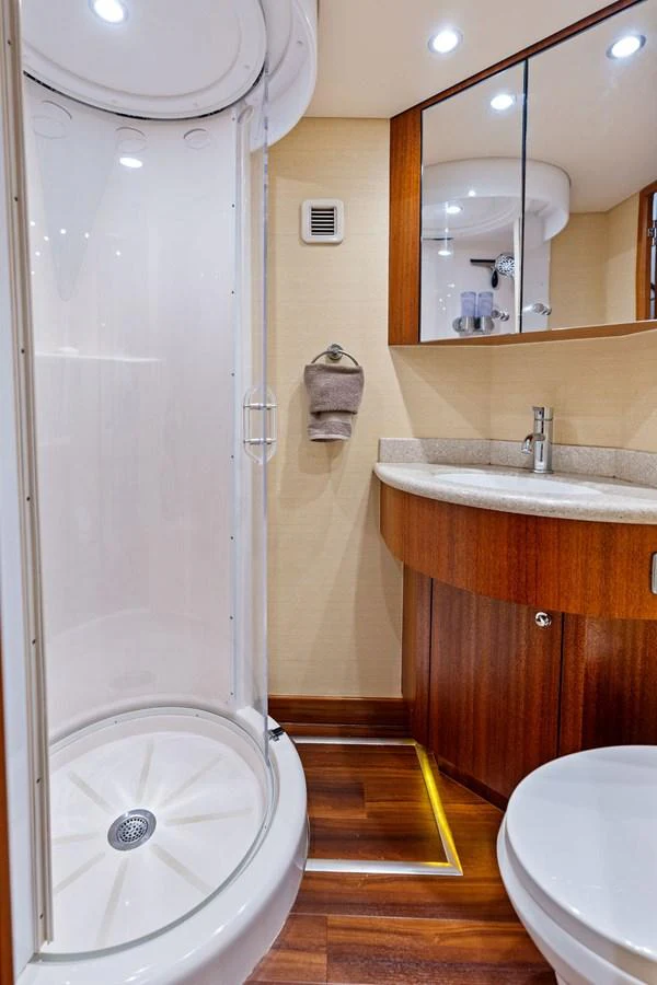 The yacht's bathroom features a modern shower enclosure and elegant wood cabinetry. aboard GRIFFIN Yacht for Sale