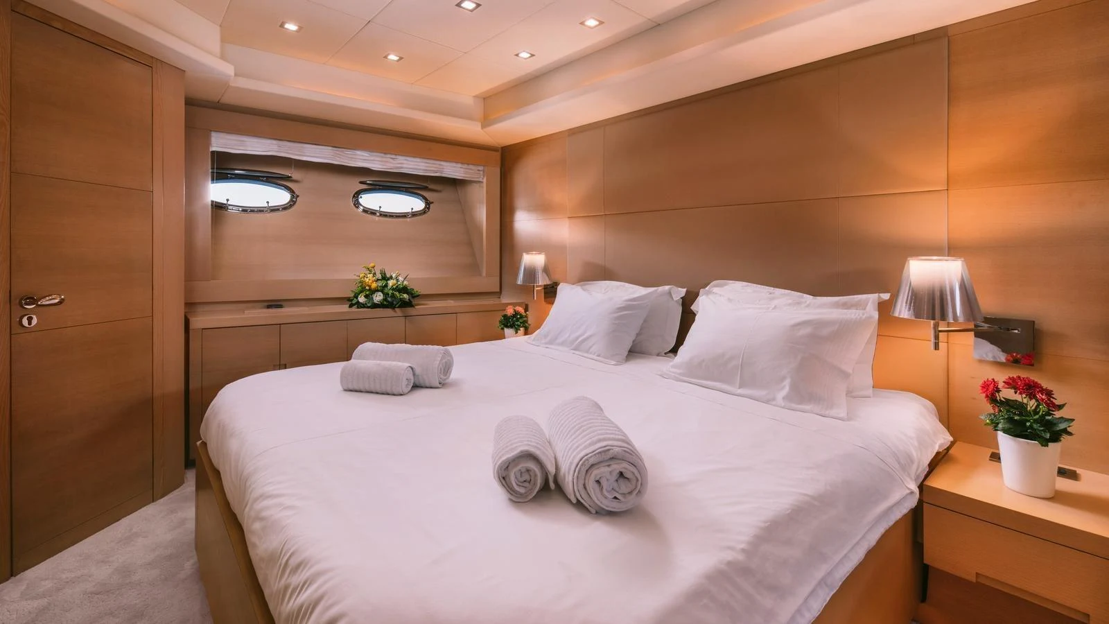 The stateroom features a plush bed with elegant lighting and modern wooden finishes. aboard THIS IS MINE Yacht for Sale