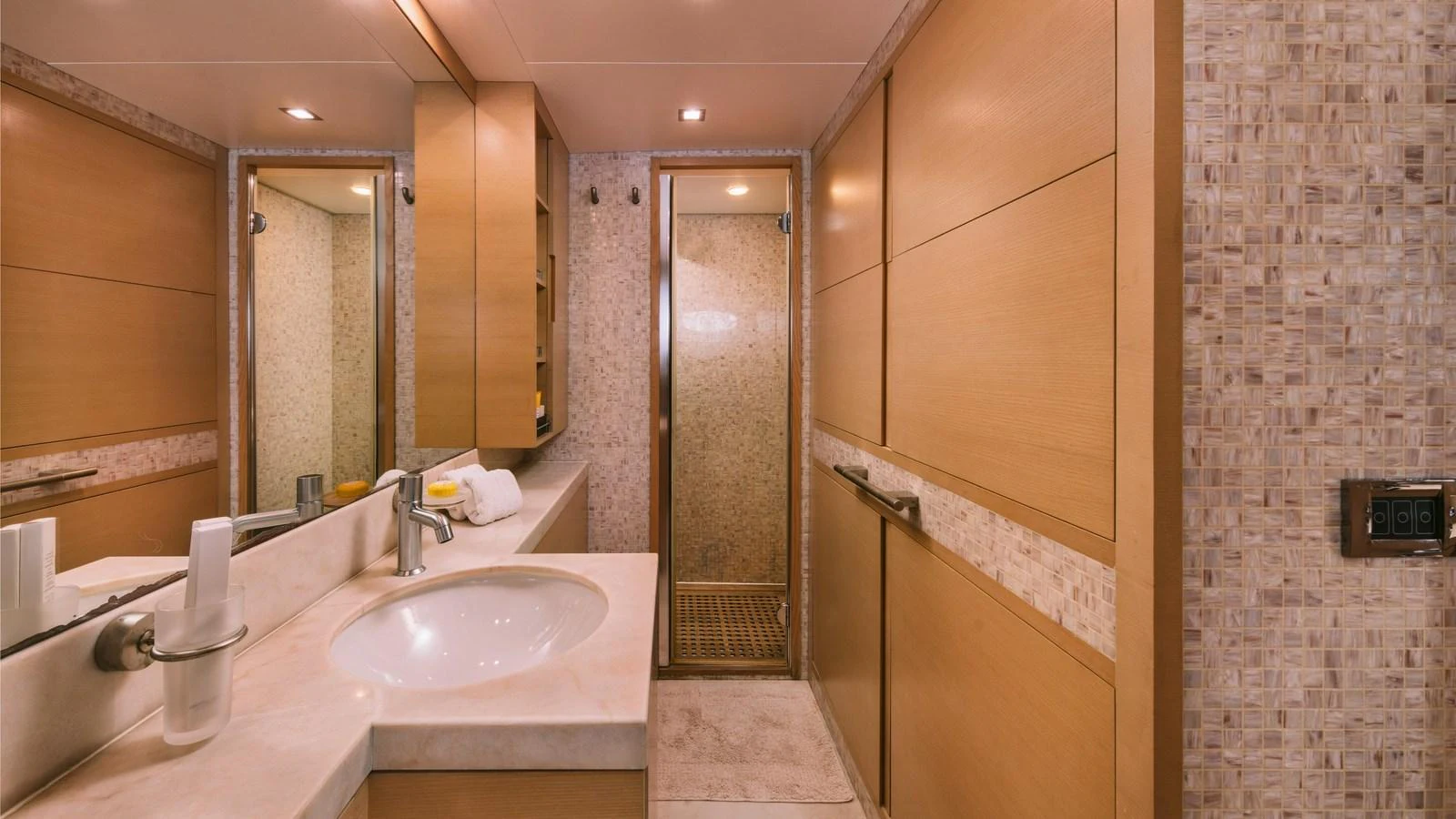 The yacht's bathroom features a sleek design with wood paneling and a spacious shower. aboard THIS IS MINE Yacht for Sale