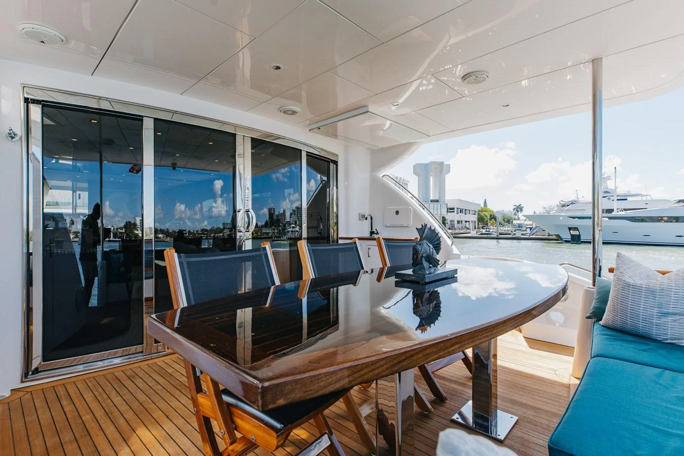The aft deck features a sleek dining area with a polished wooden table and comfortable seating, perfect for alfresco meals. aboard RITZ SEA Yacht for Sale