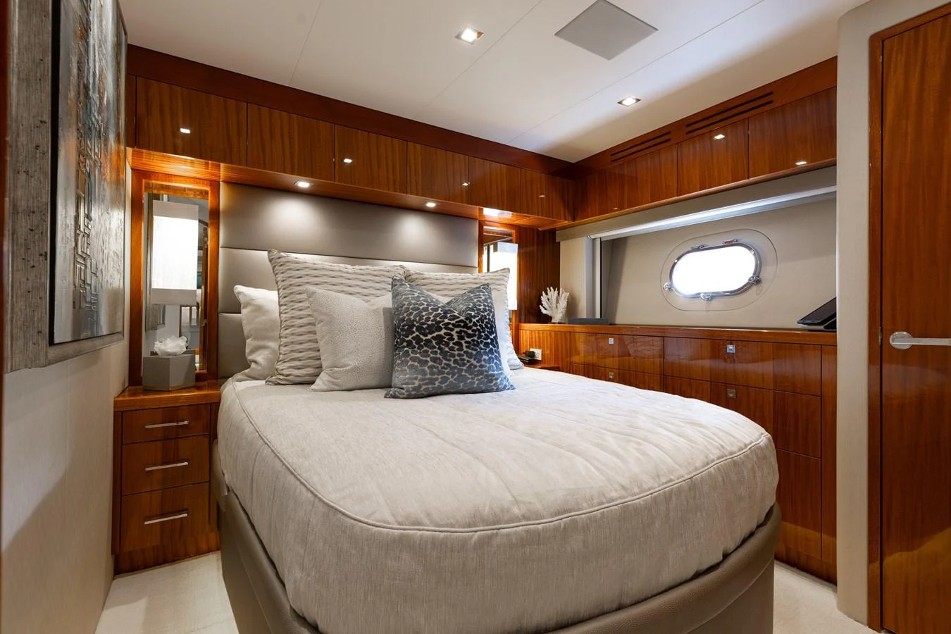 The stateroom features a plush bed, elegant wood finishes, and ample natural light from a porthole window. aboard RITZ SEA Yacht for Sale