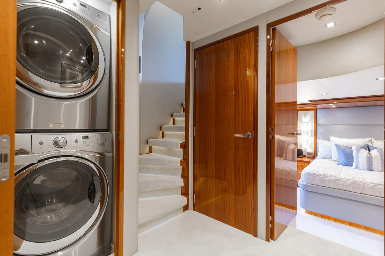 The yacht's interior features a convenient laundry area with a stacked washer and dryer, adjacent to a cozy stateroom. aboard RITZ SEA Yacht for Sale