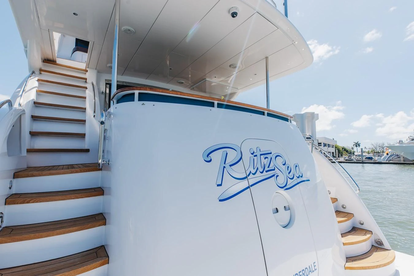 The aft deck of the yacht features elegant wooden steps and a sleek design, perfect for a luxurious maritime experience. aboard RITZ SEA Yacht for Sale