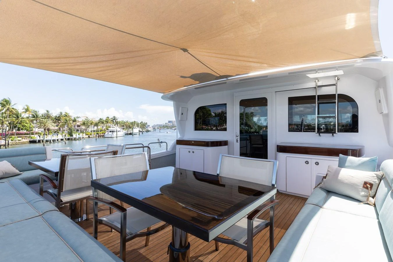 The aft deck features a shaded dining area with comfortable seating and a scenic view. aboard RITZ SEA Yacht for Sale