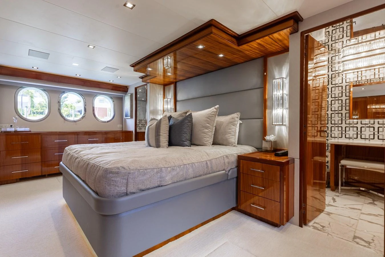 The master stateroom features a luxurious bed with plush pillows and elegant wooden accents. aboard RITZ SEA Yacht for Sale