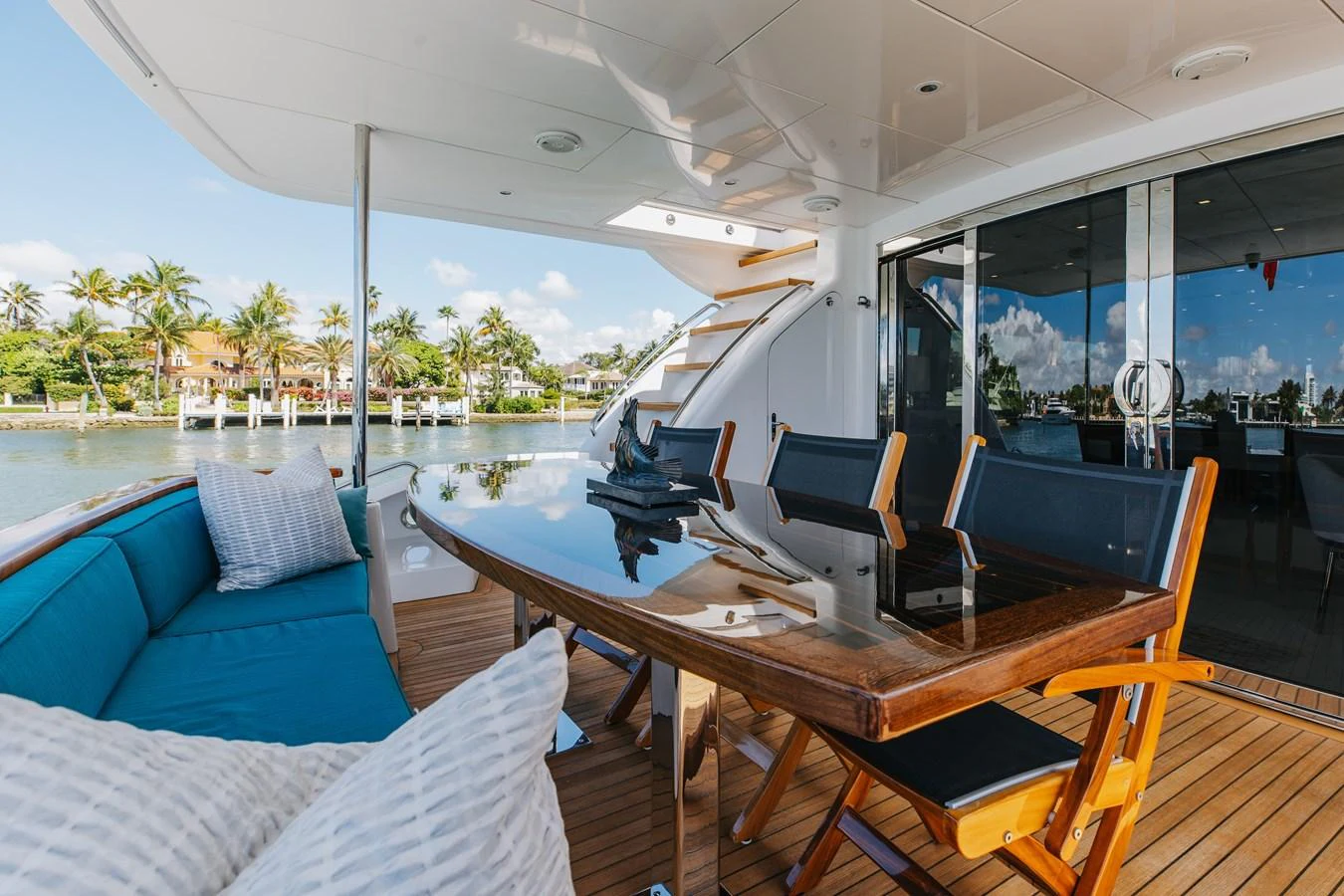 The aft deck features a stylish dining area with a polished wooden table and comfortable seating, perfect for al fresco meals. aboard RITZ SEA Yacht for Sale