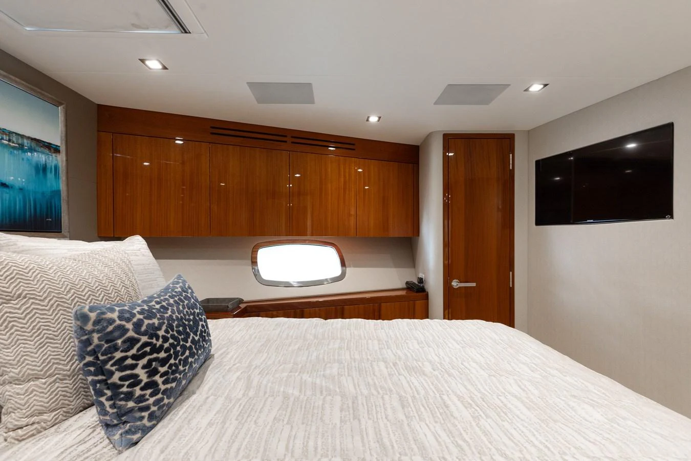 A cozy stateroom featuring a comfortable bed, wooden cabinetry, and a small window. aboard RITZ SEA Yacht for Sale