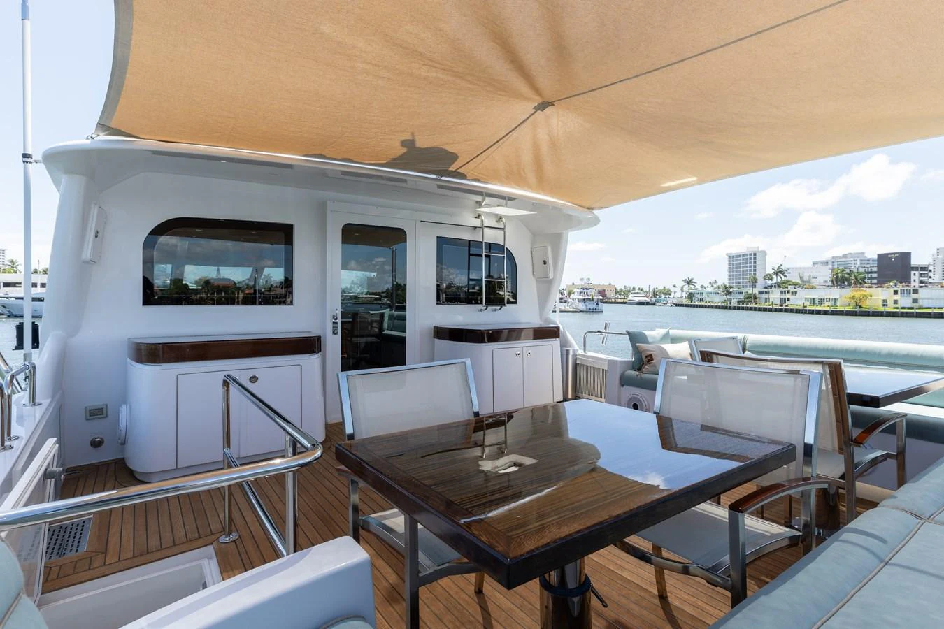 The aft deck features a shaded dining area with a sleek table and comfortable seating, perfect for alfresco meals. aboard RITZ SEA Yacht for Sale
