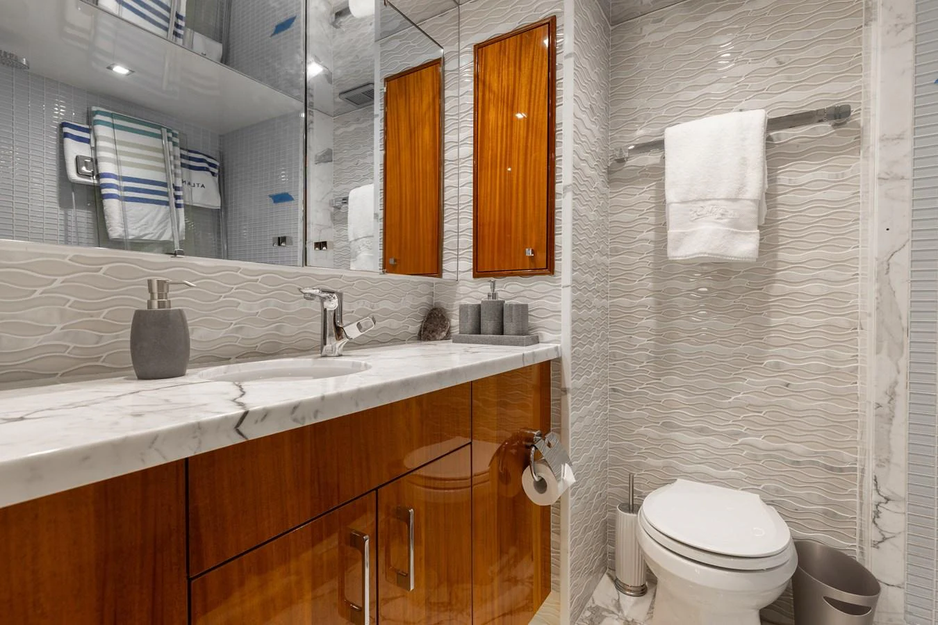 The yacht's bathroom features elegant wood cabinetry and a sleek marble countertop. aboard RITZ SEA Yacht for Sale