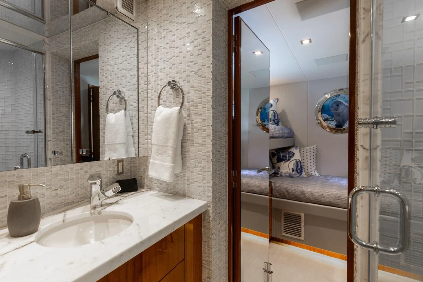 The image showcases a luxurious bathroom leading into a cozy cabin with bunk beds. aboard RITZ SEA Yacht for Sale