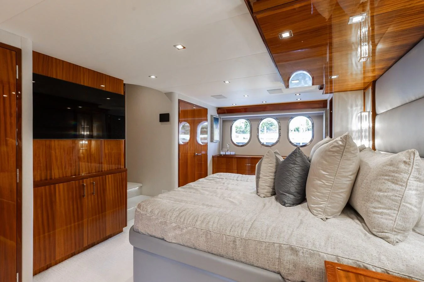 The stateroom features luxurious bedding, rich wood finishes, and ample natural light from the porthole windows. aboard RITZ SEA Yacht for Sale