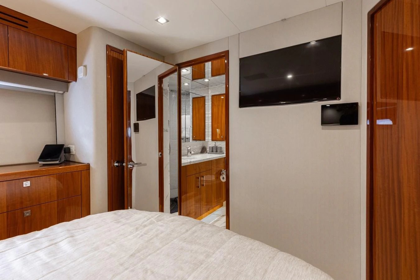 A cozy stateroom featuring a comfortable bed, wooden cabinetry, and an ensuite bathroom. aboard RITZ SEA Yacht for Sale