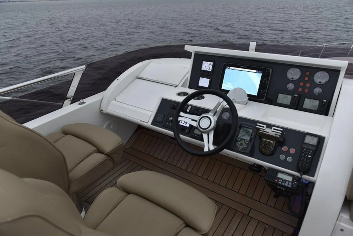 The helm station features modern navigation equipment and comfortable seating with a view of the water. aboard KAZZA Yacht for Sale