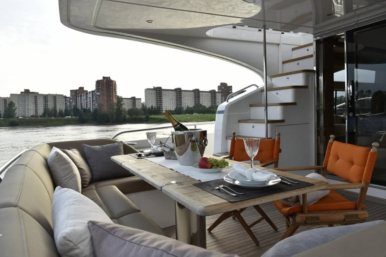 The aft deck features a cozy dining area with comfortable seating and a table set for a meal, perfect for enjoying waterfront views. aboard KAZZA Yacht for Sale