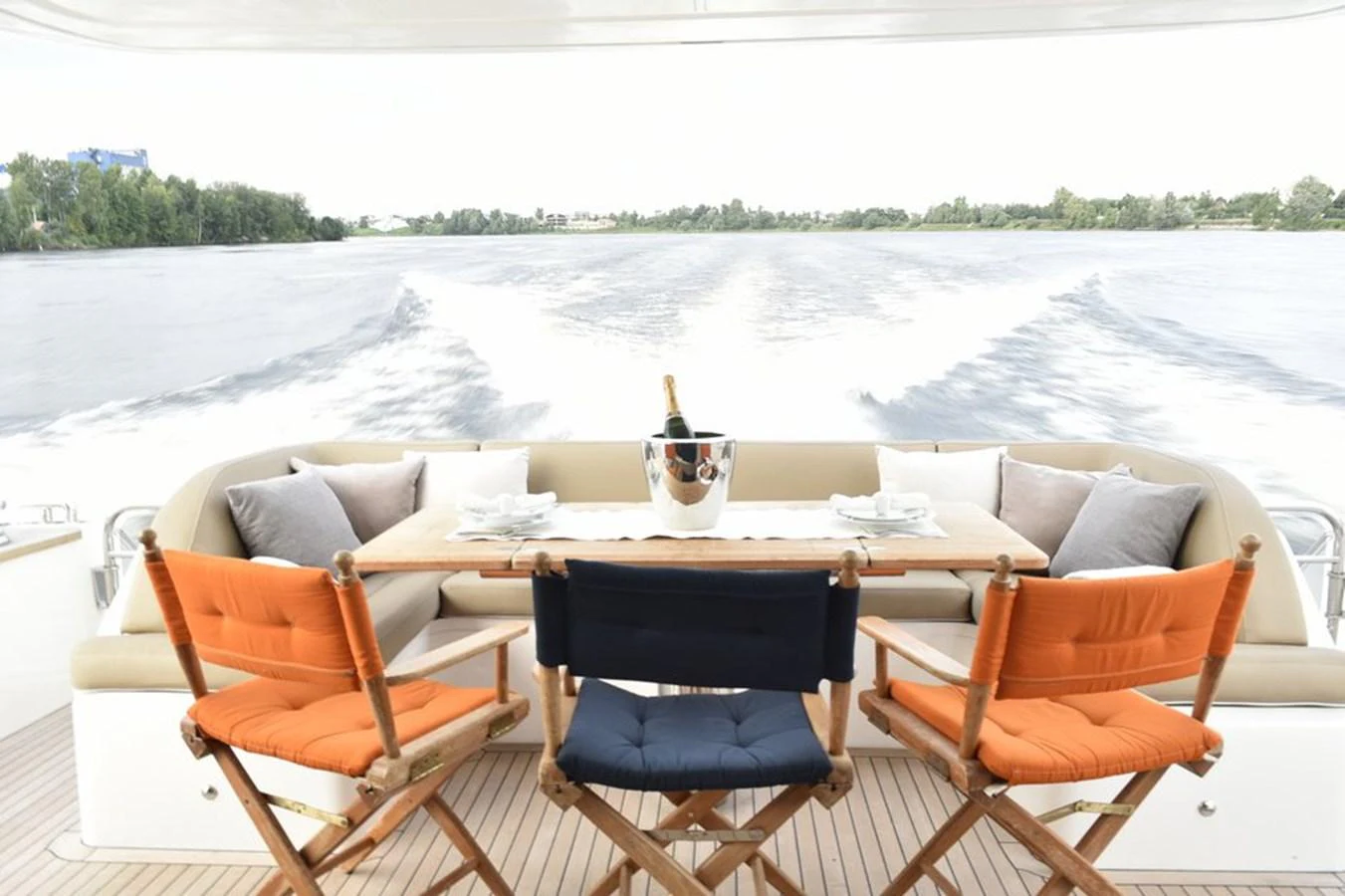 The aft deck features a cozy dining area with a view of the water. aboard KAZZA Yacht for Sale