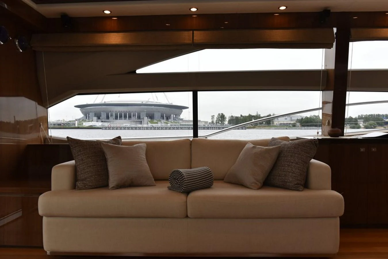 The salon features a comfortable sofa with plush cushions, offering a relaxing space with a view of the water outside. aboard KAZZA Yacht for Sale