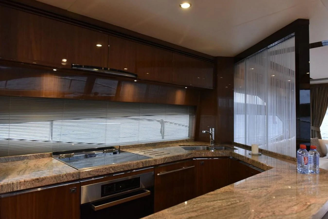 The yacht's galley features sleek wooden cabinetry and modern appliances, creating a sophisticated cooking space. aboard KAZZA Yacht for Sale