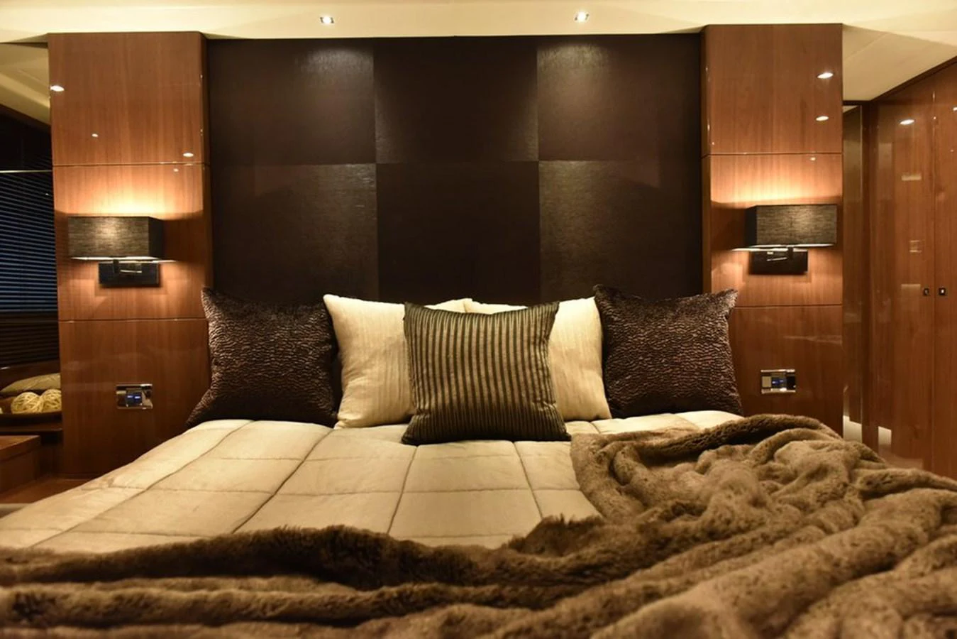 The master stateroom features a luxurious bed with plush pillows and elegant lighting. aboard KAZZA Yacht for Sale