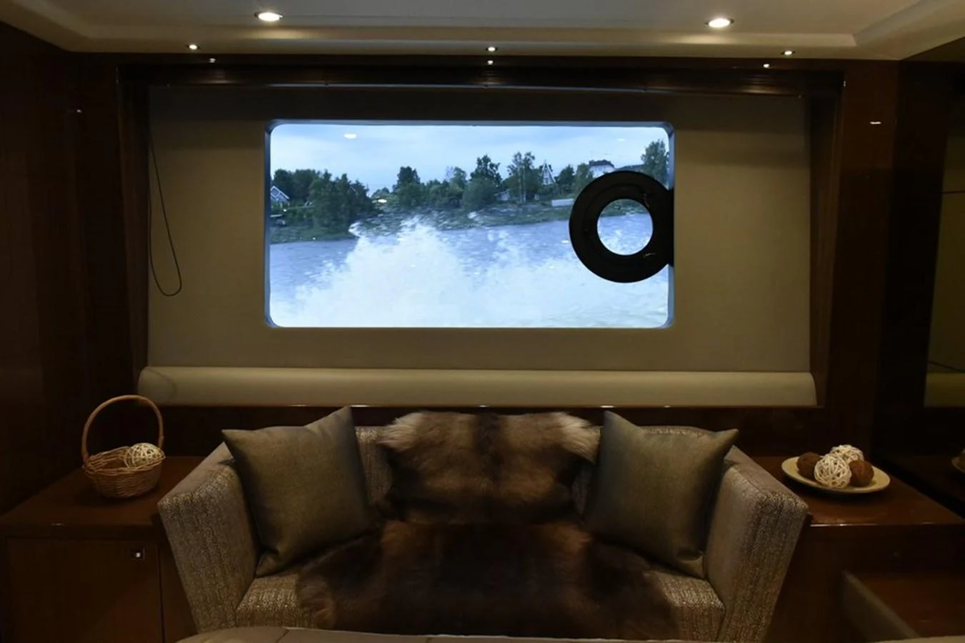 A cozy interior seating area with a large window offering a view of the water outside. aboard KAZZA Yacht for Sale