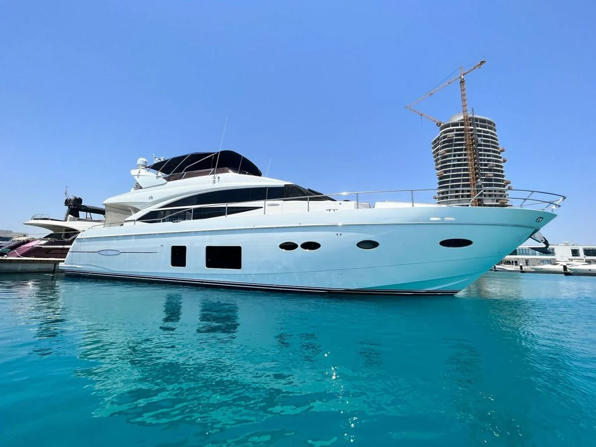 A sleek and modern yacht is docked in a serene marina, showcasing its elegant design and spacious deck. aboard KAZZA Yacht for Sale