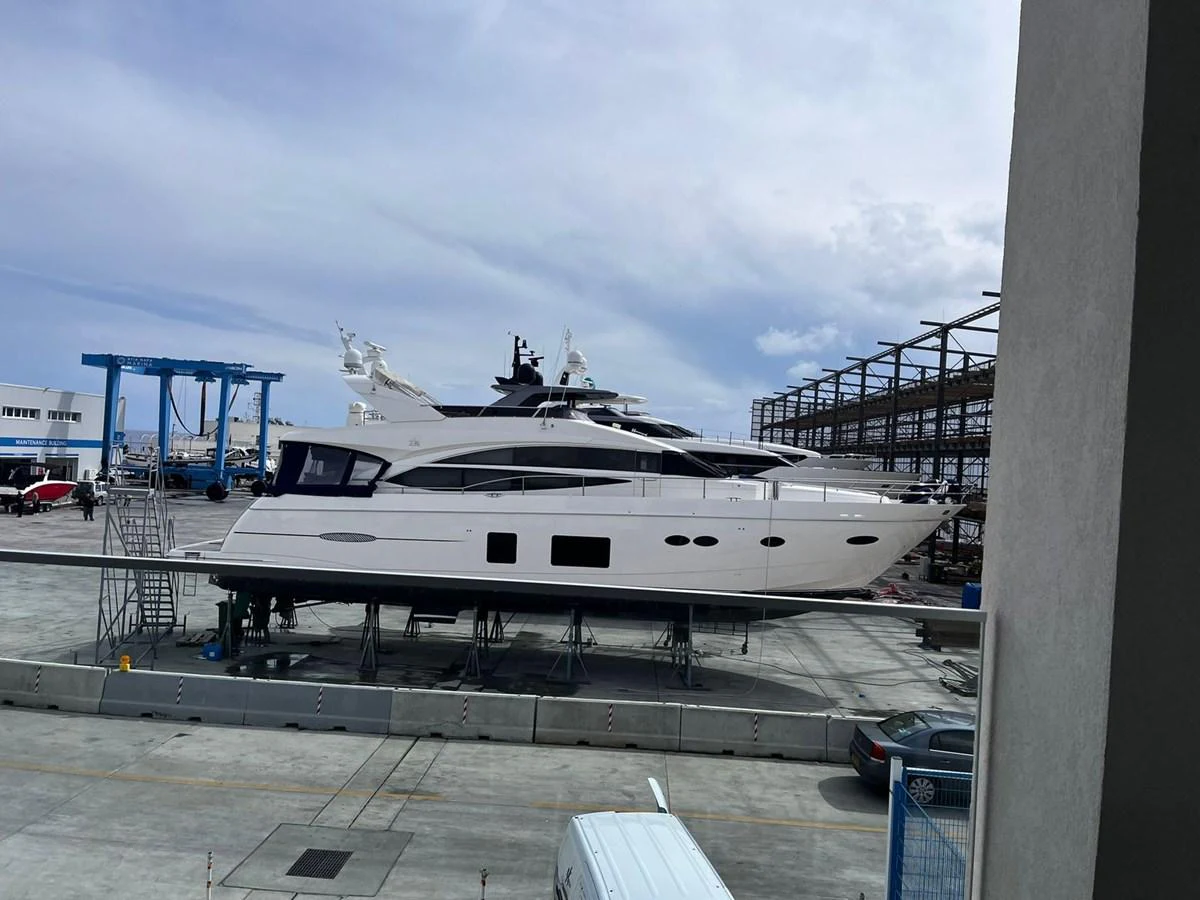 A sleek yacht is seen docked on land, showcasing its elegant profile and modern design. aboard KAZZA Yacht for Sale