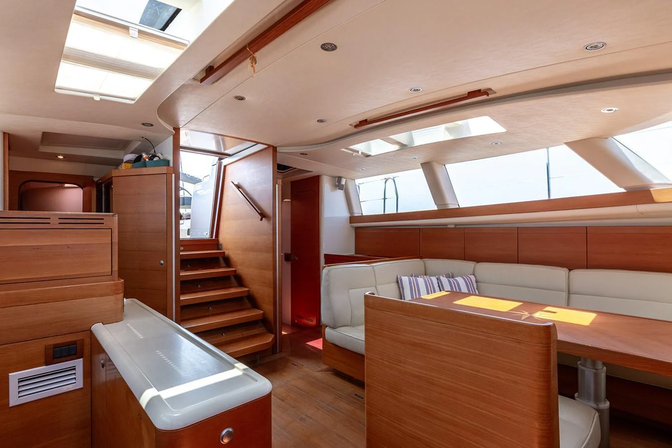 The yacht's salon features a spacious and well-lit seating area with modern wooden finishes. aboard CAIAROSSA Yacht for Sale