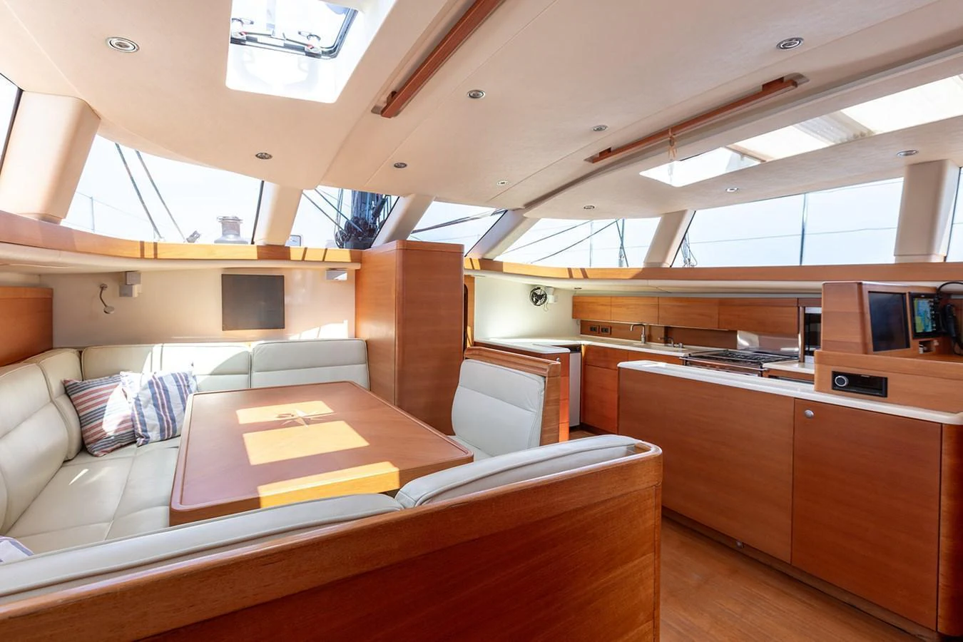The yacht's saloon features a spacious seating area with a dining table and ample natural light. aboard CAIAROSSA Yacht for Sale