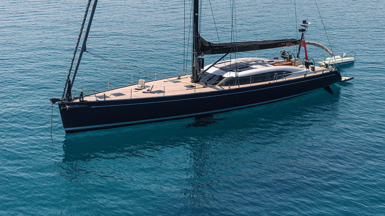 A sleek sailing yacht glides gracefully on calm, clear waters. aboard CAIAROSSA Yacht for Sale