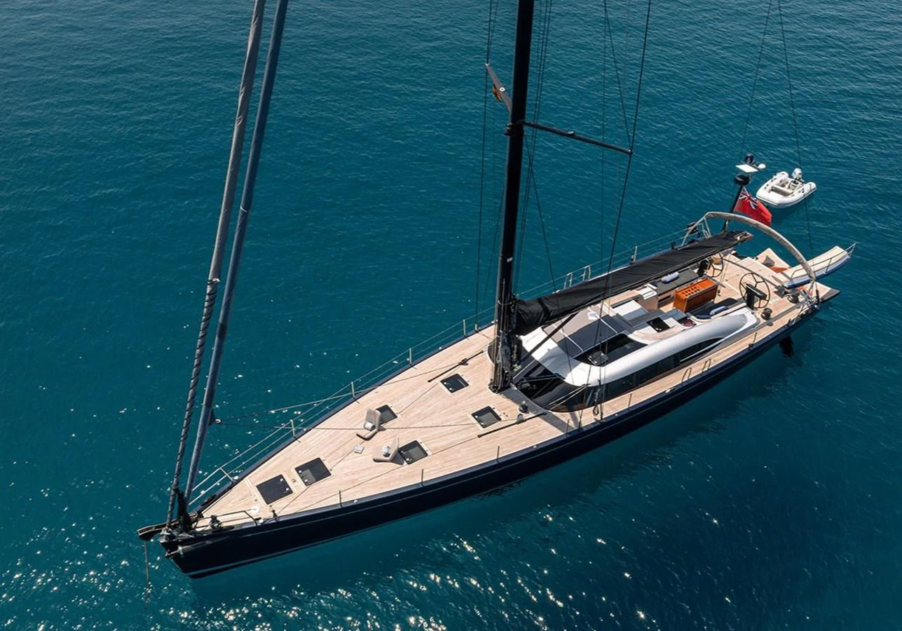 A sleek sailing yacht glides gracefully on the open water, showcasing its elegant design and spacious deck. aboard CAIAROSSA Yacht for Sale
