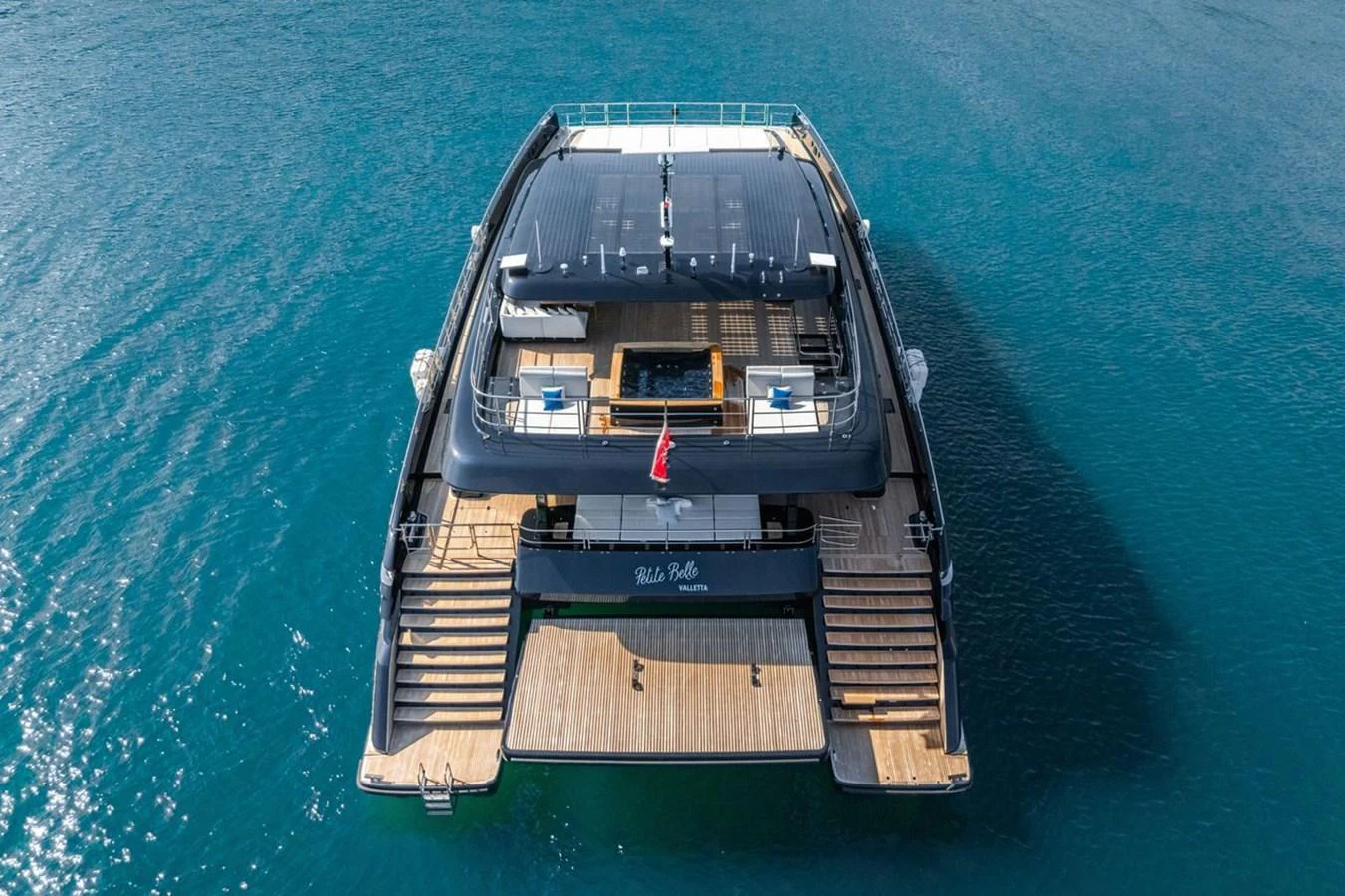 The yacht's aft deck features expansive teak decking and multiple levels for relaxation and entertainment. aboard PETITE BELLE Yacht for Sale