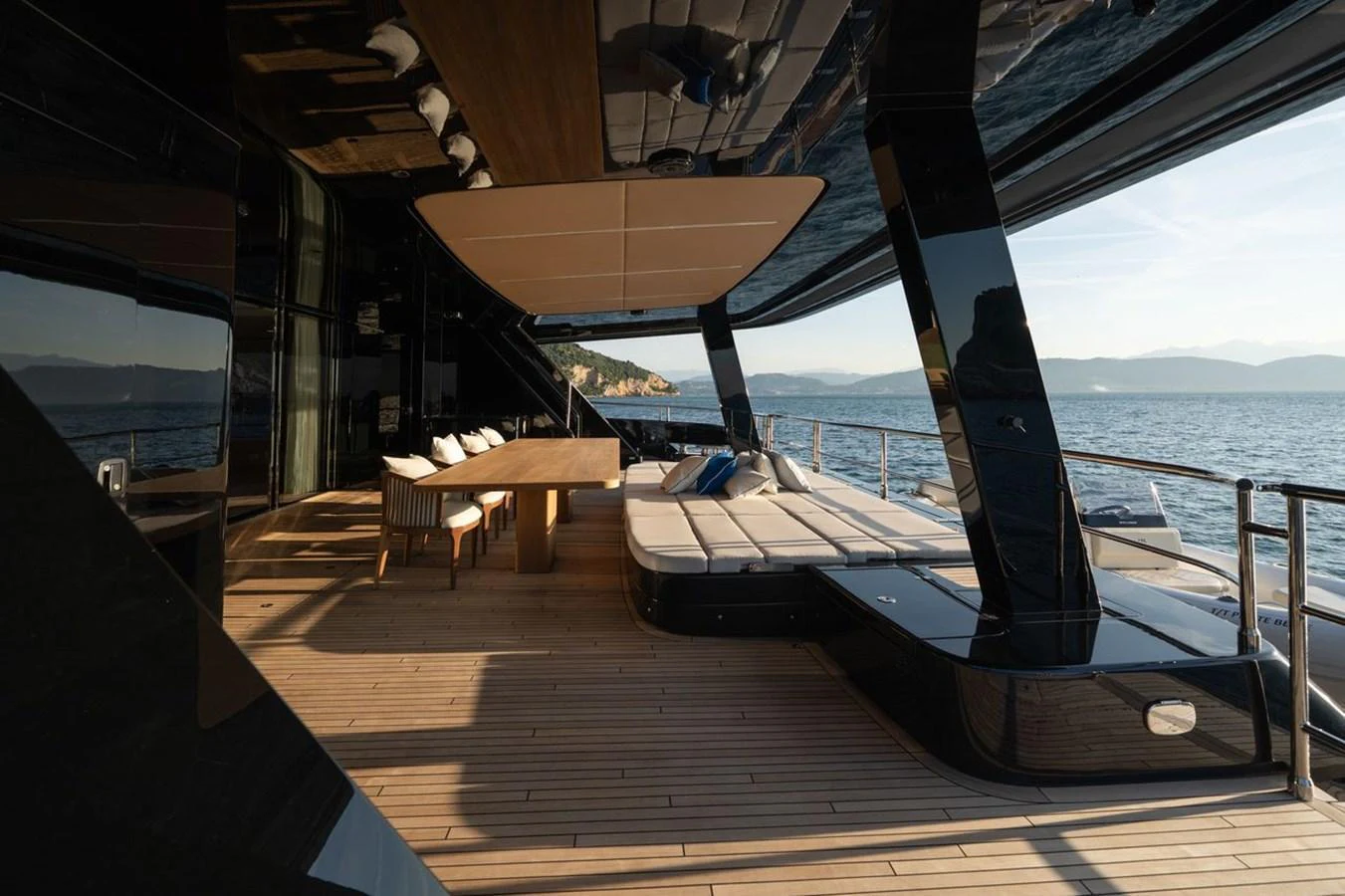 The aft deck features a spacious lounging area with a large dining table and comfortable seating, perfect for enjoying the sea views. aboard PETITE BELLE Yacht for Sale