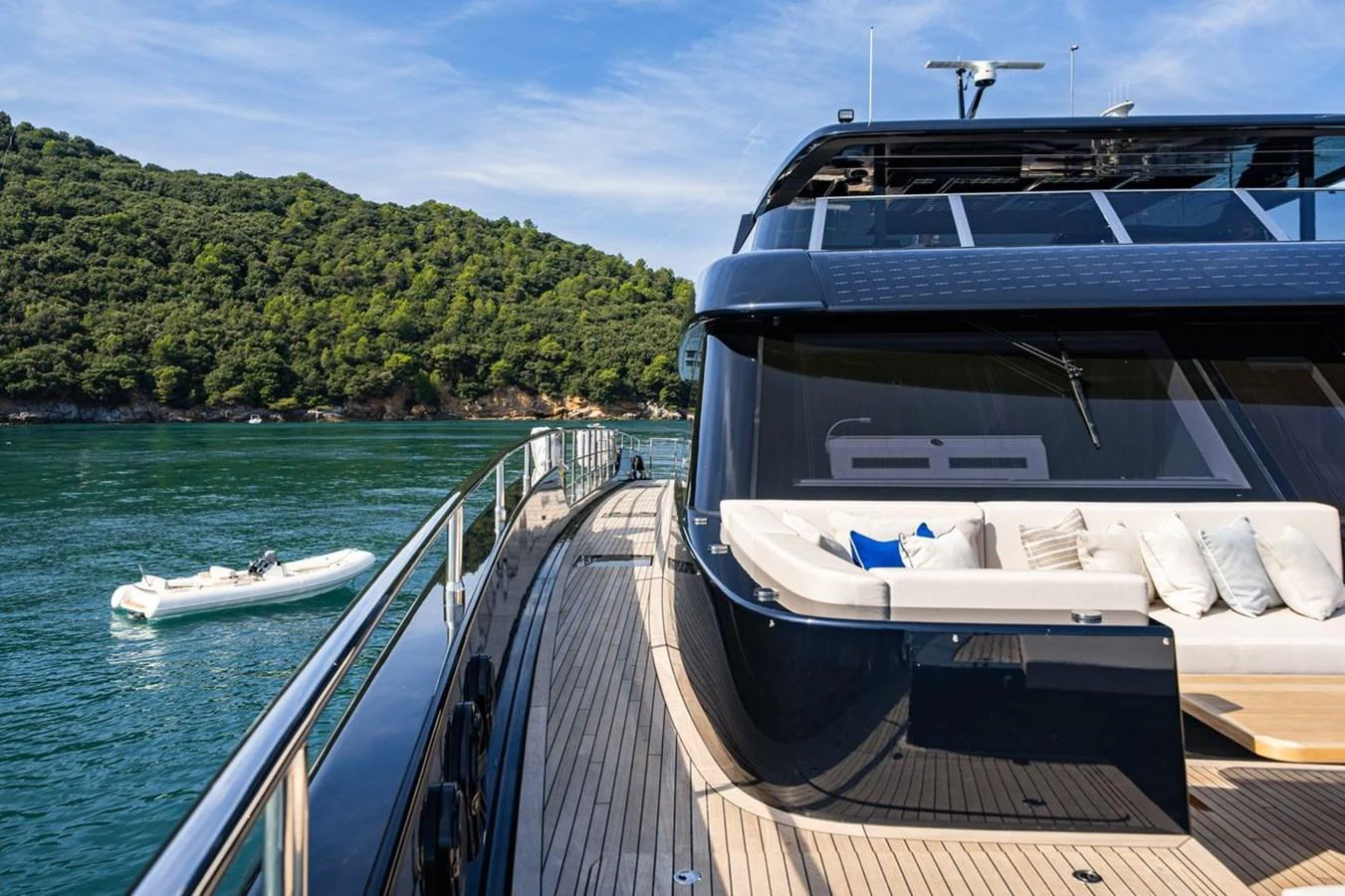 The yacht's sleek side deck offers a luxurious space with comfortable seating and stunning views of the surrounding water and greenery. aboard PETITE BELLE Yacht for Sale