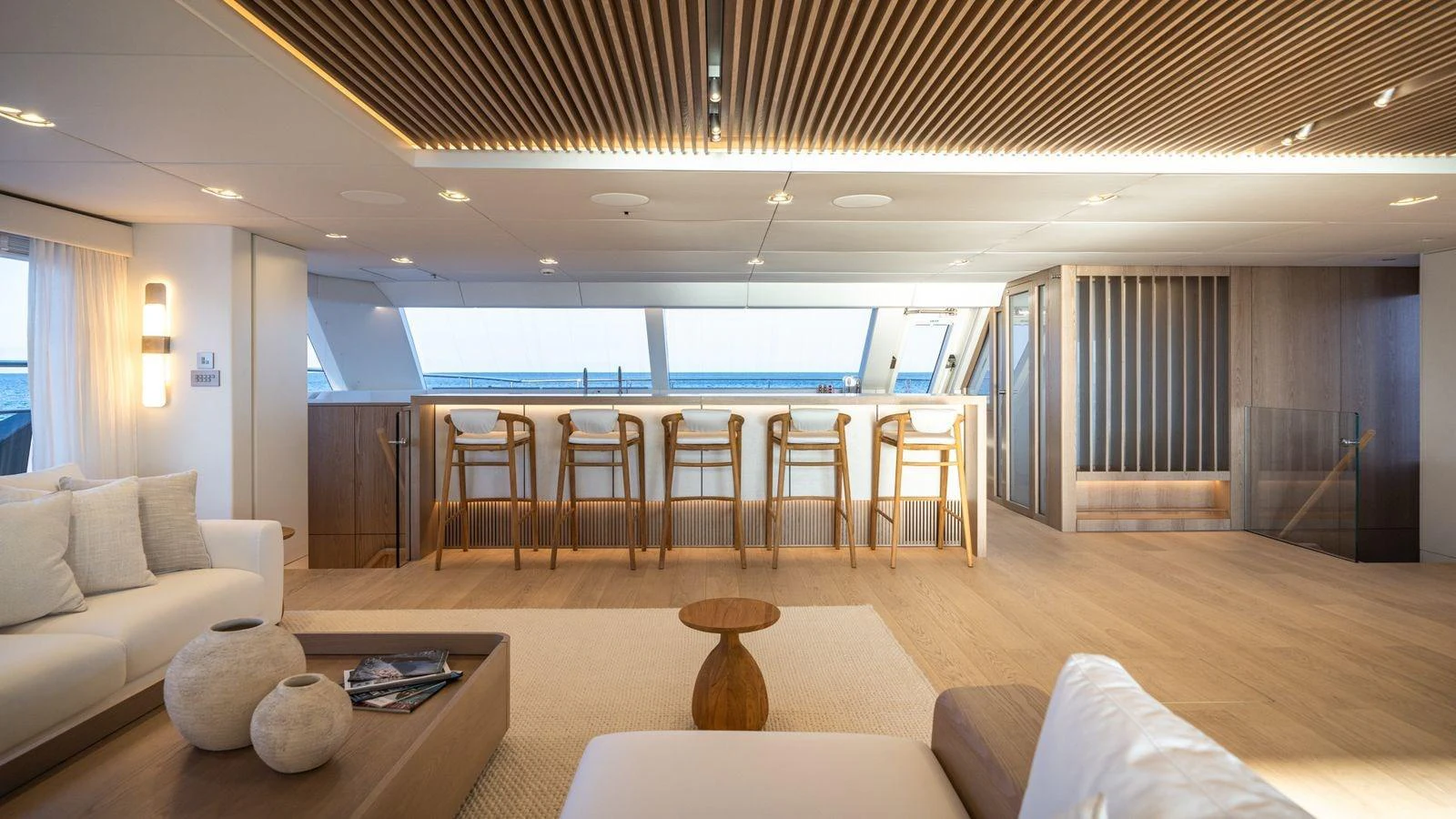 The salon features a stylish bar area with panoramic windows offering stunning sea views. aboard PETITE BELLE Yacht for Sale