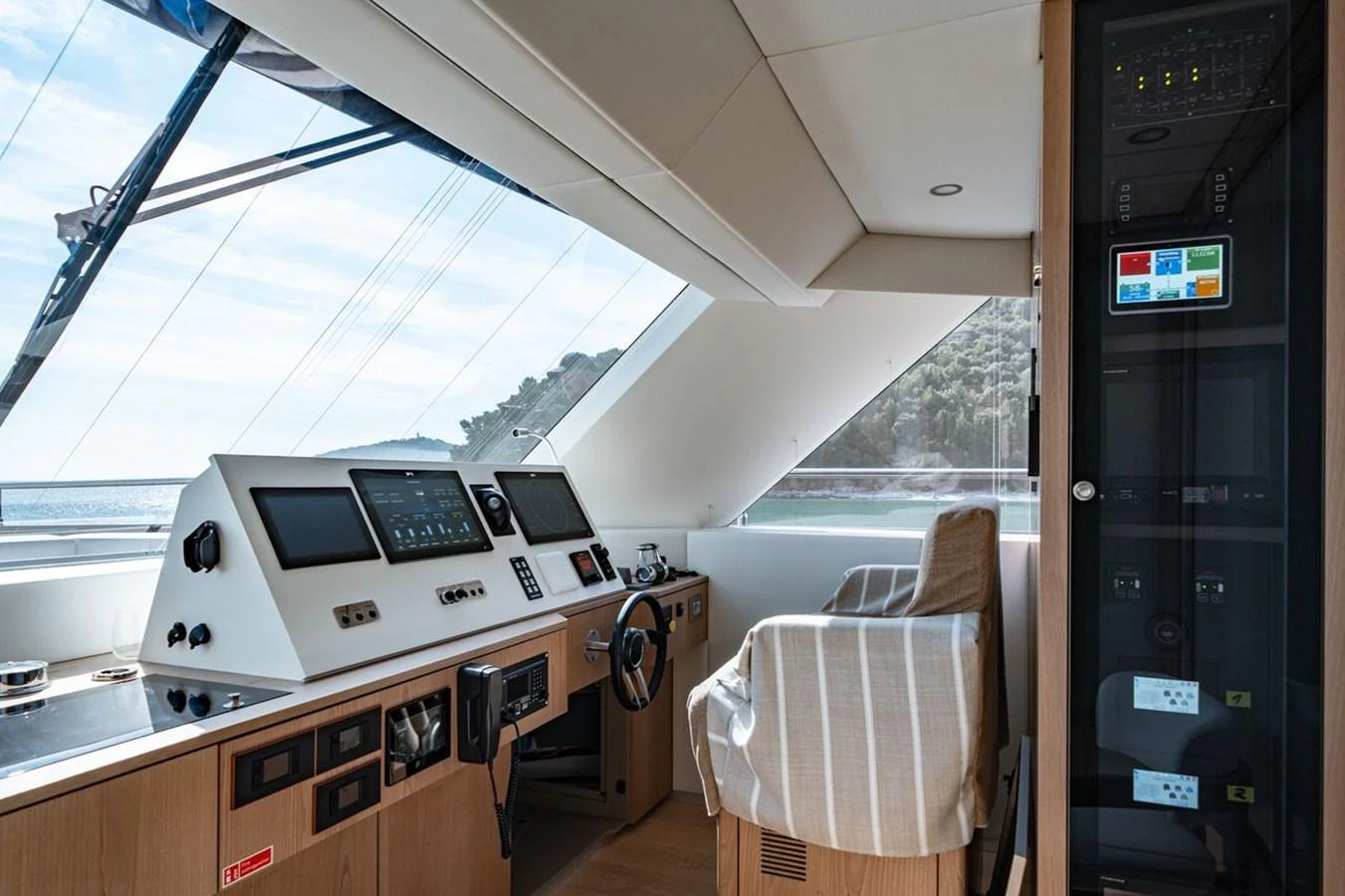 The helm station offers a commanding view with advanced navigation equipment and a comfortable captain's chair. aboard PETITE BELLE Yacht for Sale