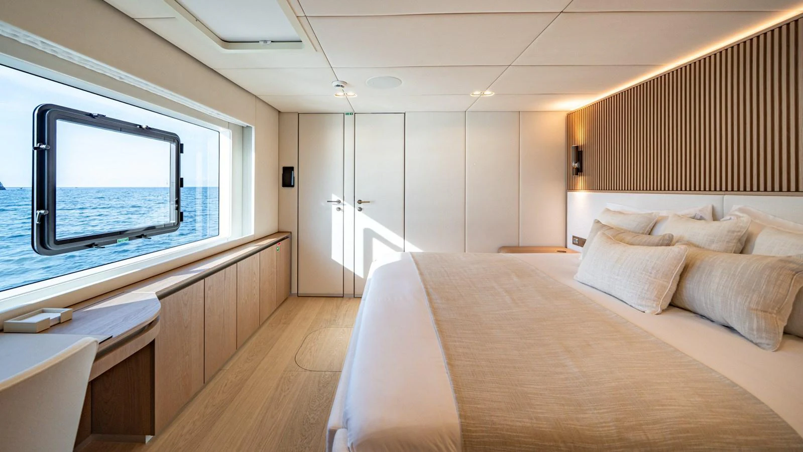 A luxurious stateroom with a large window offering stunning sea views. aboard PETITE BELLE Yacht for Sale