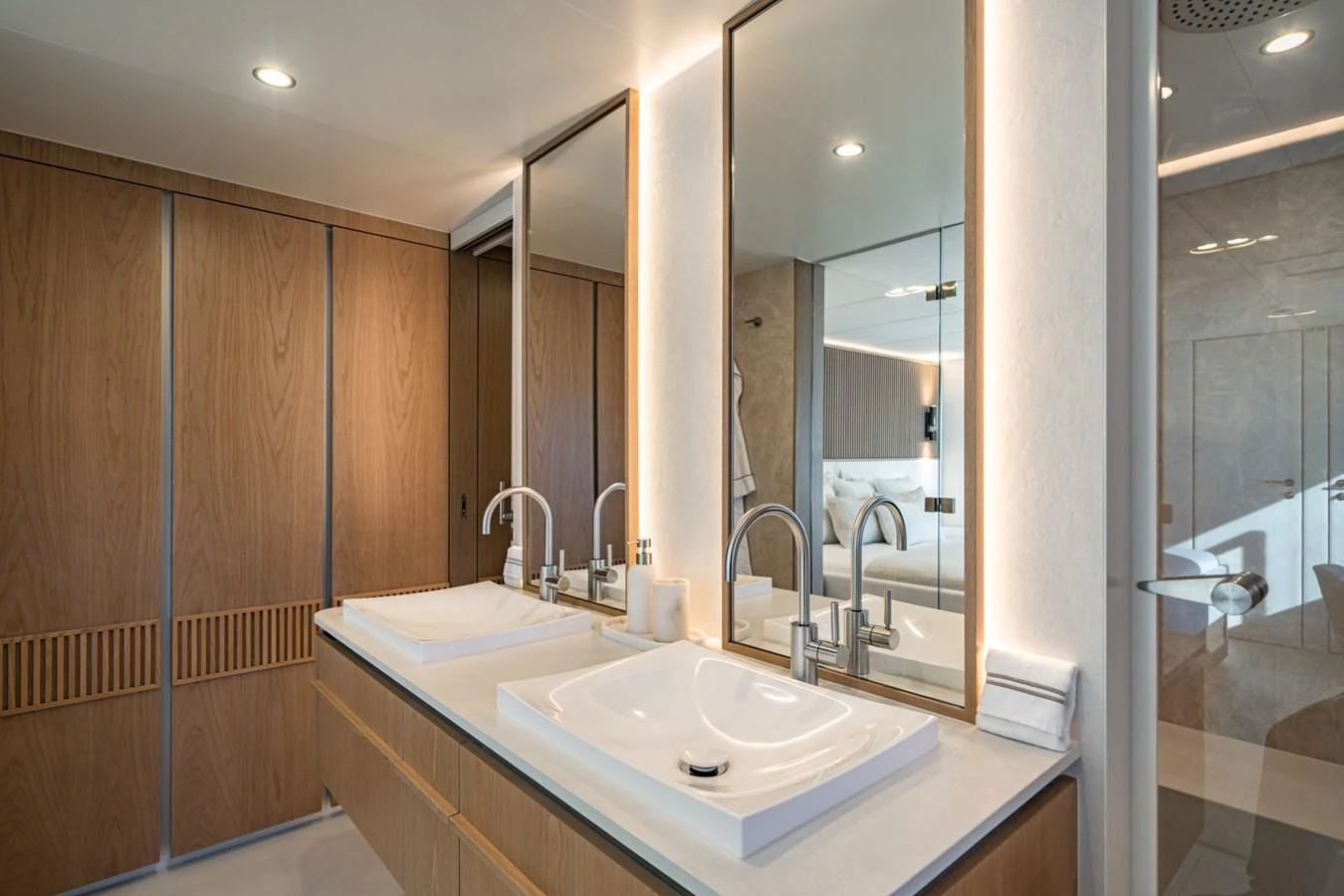 The yacht's bathroom features a modern design with dual sinks and elegant wood paneling. aboard PETITE BELLE Yacht for Sale