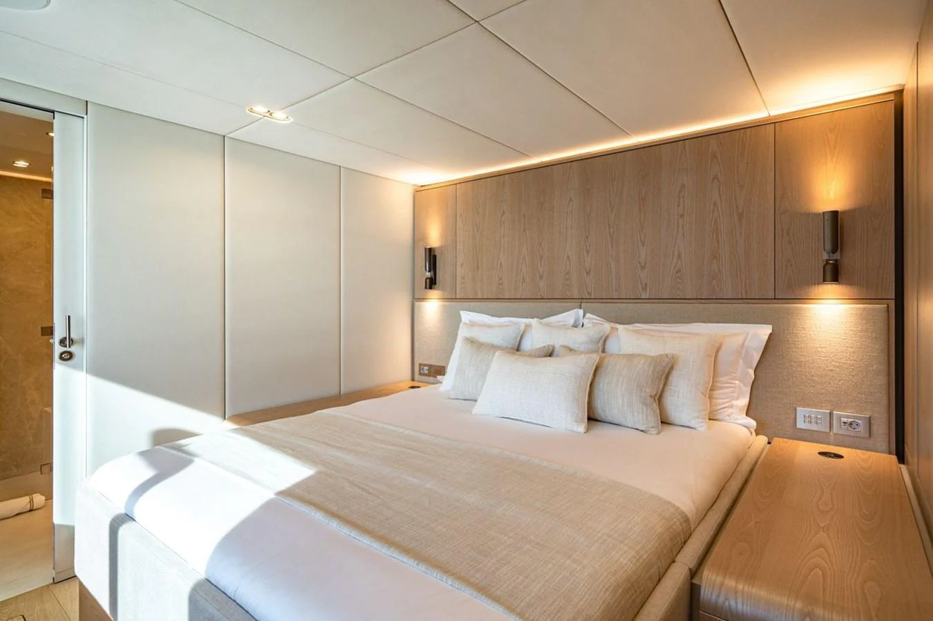 A luxurious stateroom with a large bed and elegant lighting. aboard PETITE BELLE Yacht for Sale