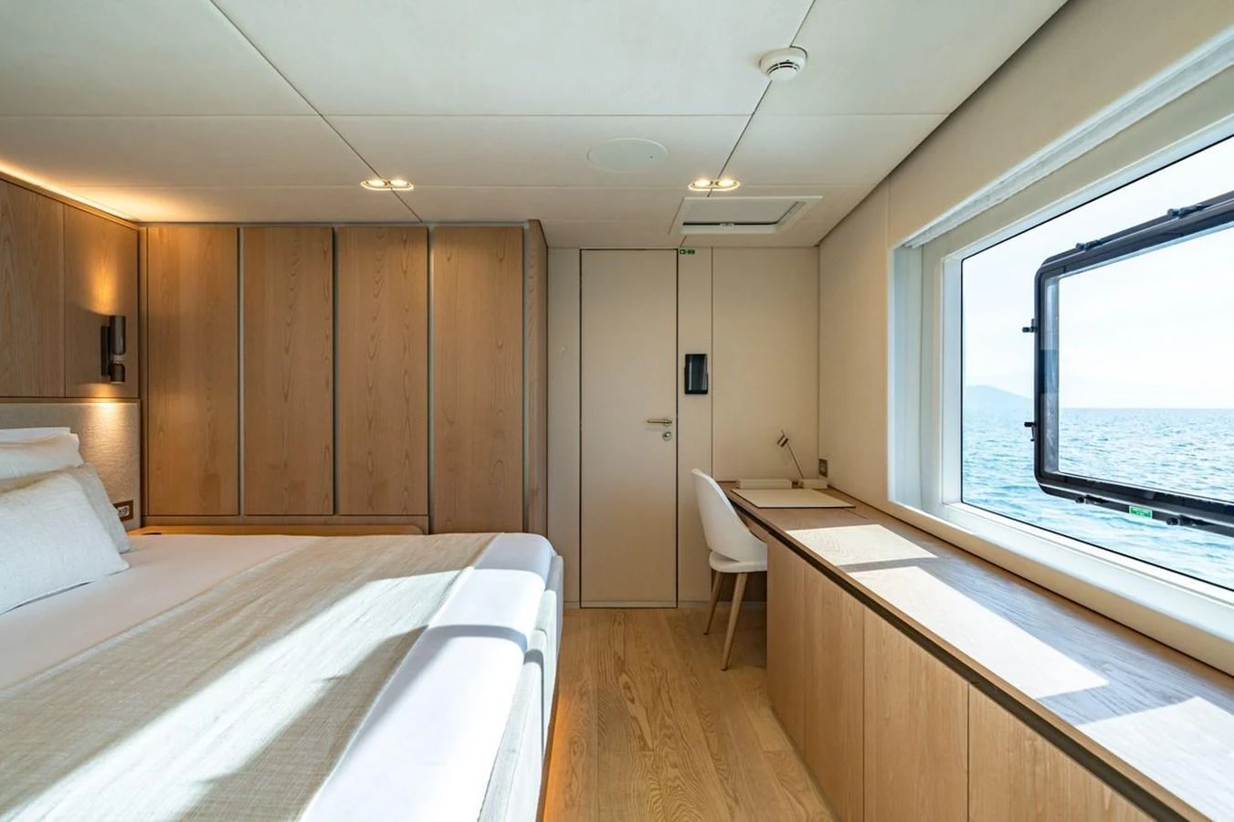A serene stateroom with a large window offering a stunning ocean view. aboard PETITE BELLE Yacht for Sale