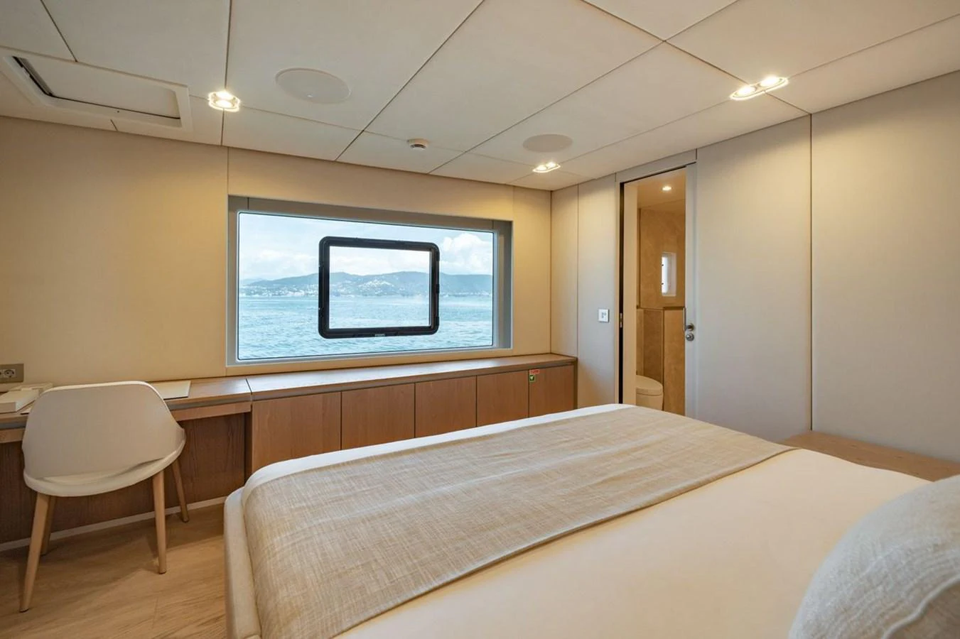 A serene stateroom with a large window offering a stunning sea view. aboard PETITE BELLE Yacht for Sale