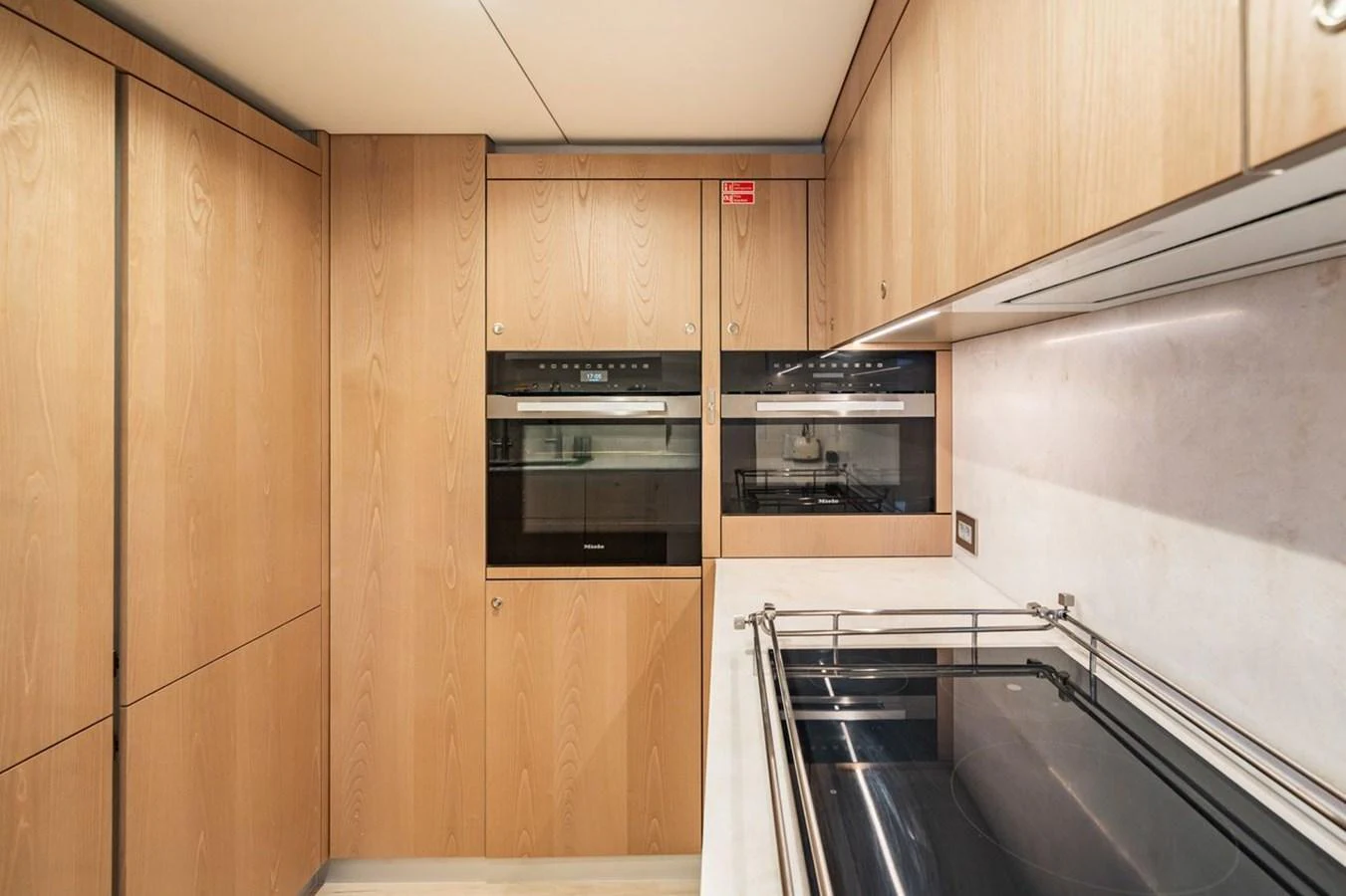 The galley features modern appliances and sleek wooden cabinetry, creating a functional and stylish space for culinary activities. aboard PETITE BELLE Yacht for Sale