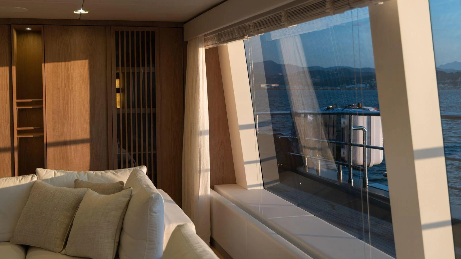 The yacht's interior features a cozy seating area with large windows offering stunning ocean views. aboard PETITE BELLE Yacht for Sale