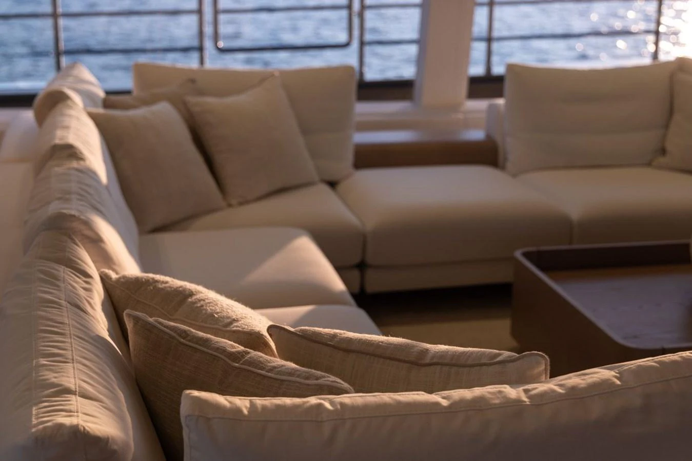 The salon features a plush seating area with a view of the sea through large windows. aboard PETITE BELLE Yacht for Sale