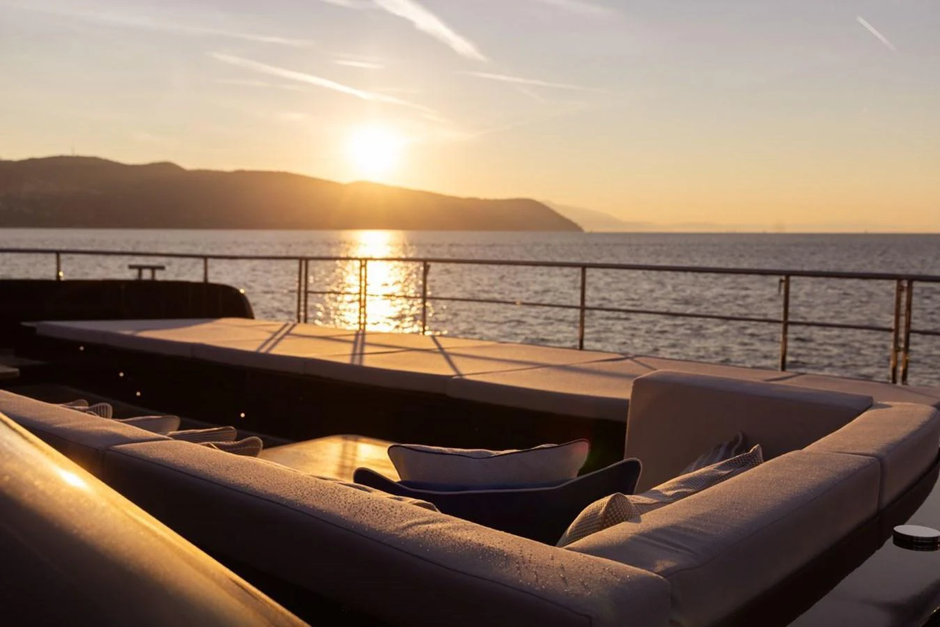 The sundeck offers a serene setting with plush seating and a stunning sunset view over the water. aboard PETITE BELLE Yacht for Sale