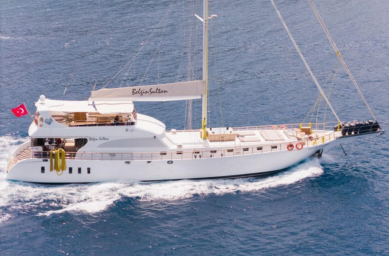 A sleek white yacht cruises gracefully on the open sea, showcasing its elegant design and spacious deck areas. aboard BELGIN SULTAN Yacht for Sale