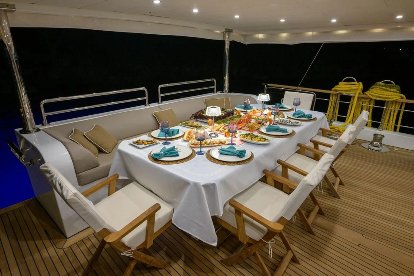 The aft deck features an elegant dining setup with a beautifully arranged table for a luxurious meal experience. aboard BELGIN SULTAN Yacht for Sale